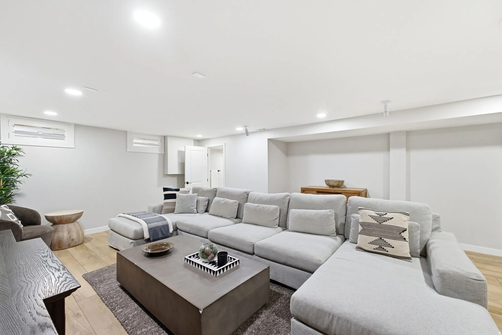 Recessed lighting, wood-finish flooring, white walls, and a white paneled door