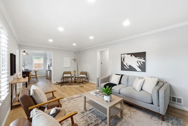 Recessed lighting, crown molding, wood-finish flooring, white plantation shutters, and a framed doorway
