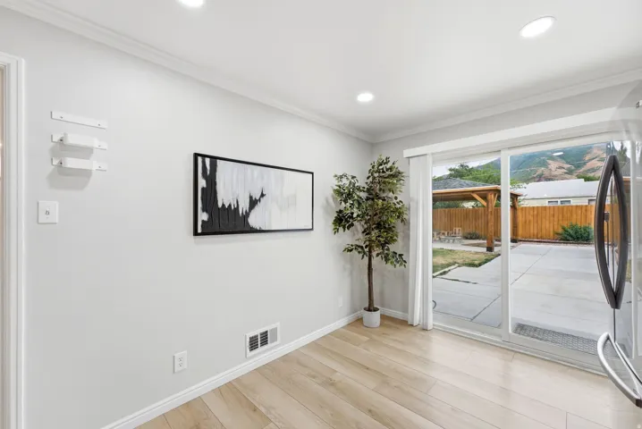 Recessed lighting, wood-finish flooring, sliding glass door, and backyard access featuring a wooden pergola and fencing