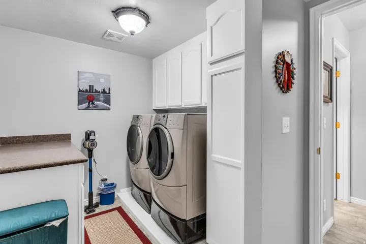 Laundry area featuring white cabinetry, a built-in counter surface, and a flush mount ceiling light fixture