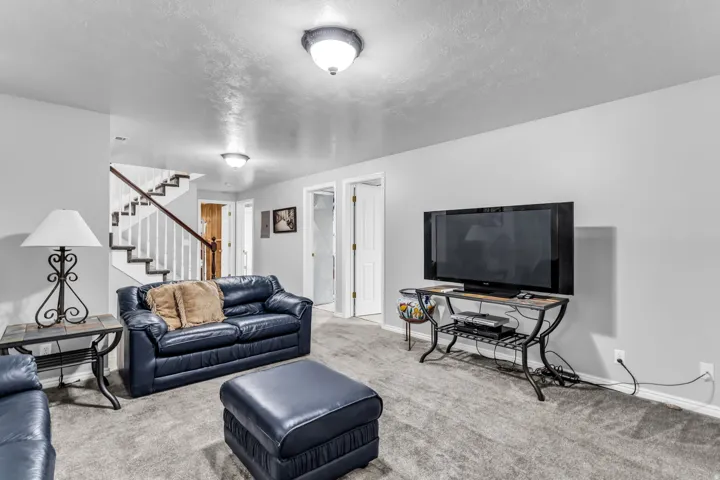 Carpeted living area with light gray walls, white trim, and recessed lighting