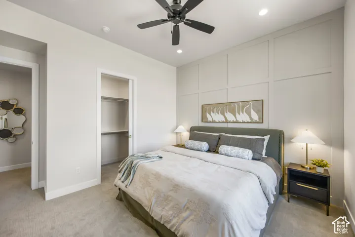 Carpeted flooring, recessed lighting, ceiling fan, board and batten wall accent, and a built-in closet with shelving