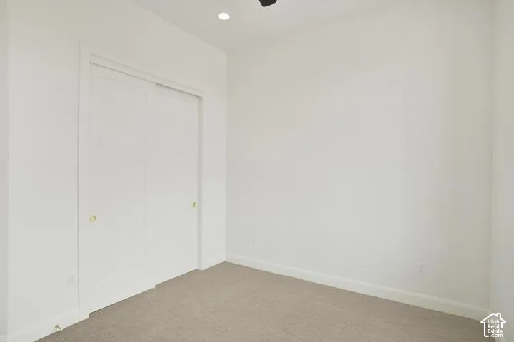 Neutral wall finishes, recessed ceiling lighting, light-toned carpet flooring, and white sliding closet doors