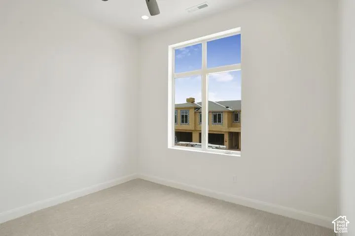 Room with neutral carpeting and white walls