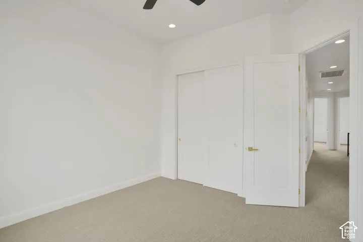 Recessed lighting, ceiling fan, neutral carpet flooring, and white panel doors