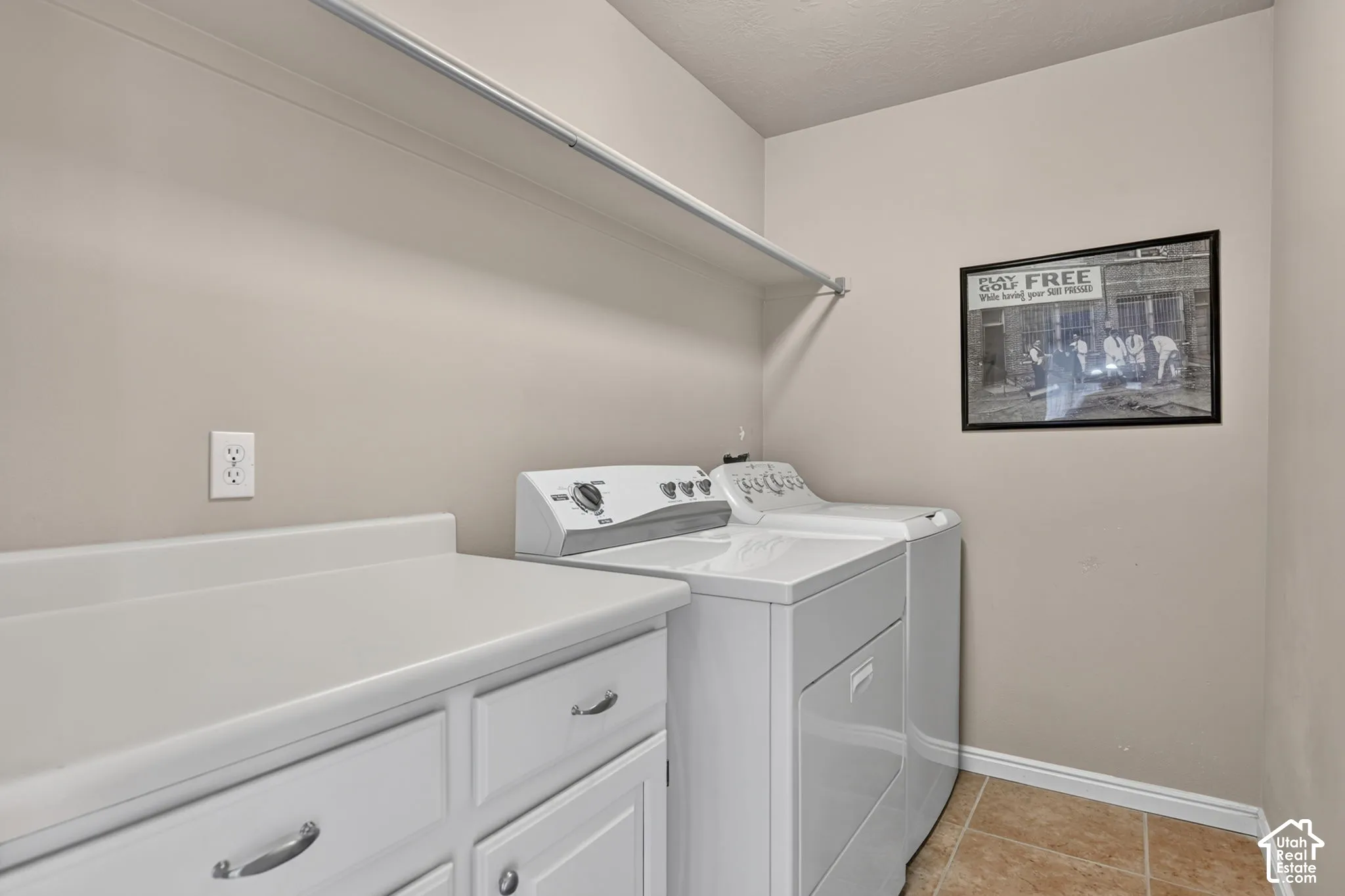 White cabinetry with pull hardware, light countertop, and tile flooring