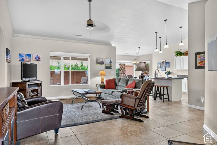 Open-concept living area featuring tile flooring, a ceiling fan, and pendant lighting