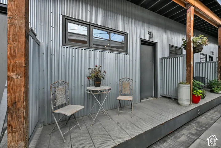 Corrugated metal siding, dark-framed windows, and an elevated outdoor deck area create a distinctive exterior
