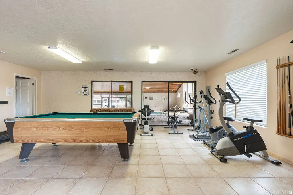 Recreation room featuring a billiards table, fitness equipment, and tiled flooring