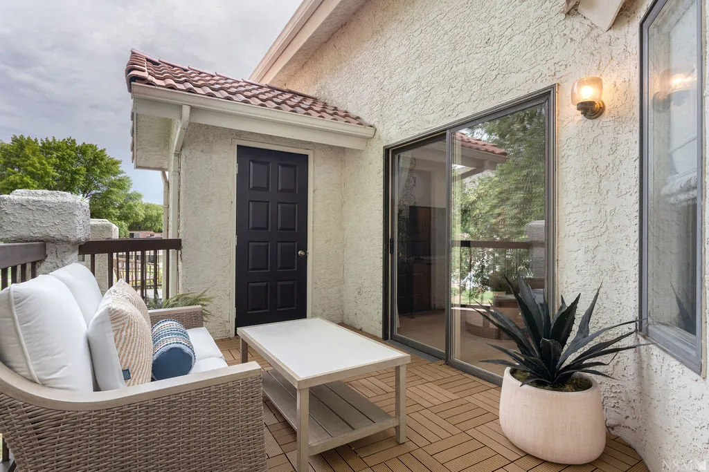 Private balcony featuring new flooring, a sliding glass door, and an exterior light fixture