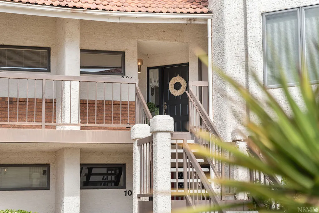 Exterior with stucco finish, terra cotta roof tiles, and wood balustrade