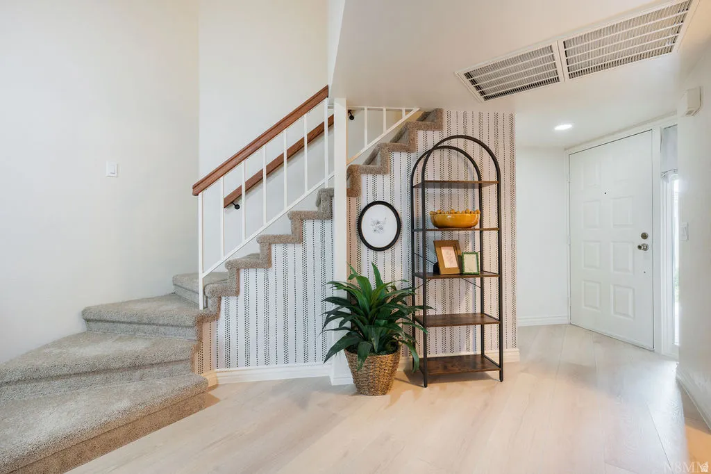 Carpeted staircase with white balusters and a wood handrail