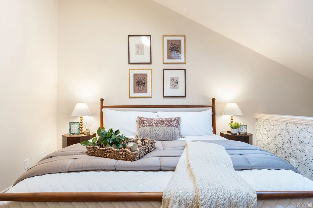 Sloped ceiling, built-in half-wall with patterned accent, and neutral wall tones