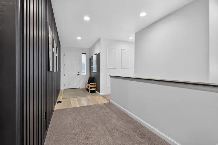 Entryway featuring a paneled accent wall, recessed lighting, and light wood-finish flooring