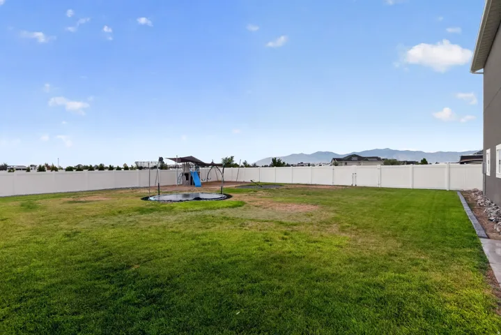 Expansive lawn area with a perimeter fence, offering a broad open space