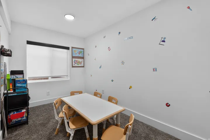 Recessed lighting, large window with roller shade, neutral wall paint, carpeted flooring, and baseboard molding