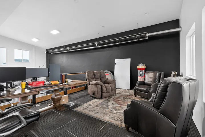 Spacious room featuring multiple windows, a sloped ceiling, and dark accent walls