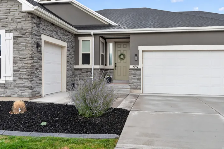 Stone veneer and stucco exterior with multiple garage doors