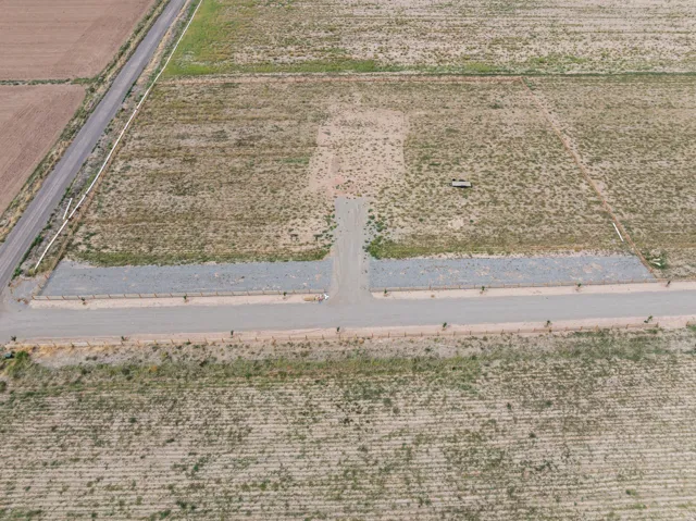 Expansive undeveloped lot with a gravel access road and cleared building site