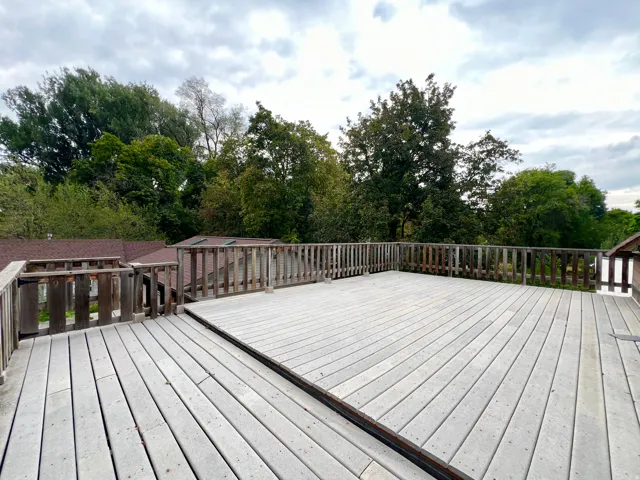 Expansive rooftop deck with wood planking and wood railings