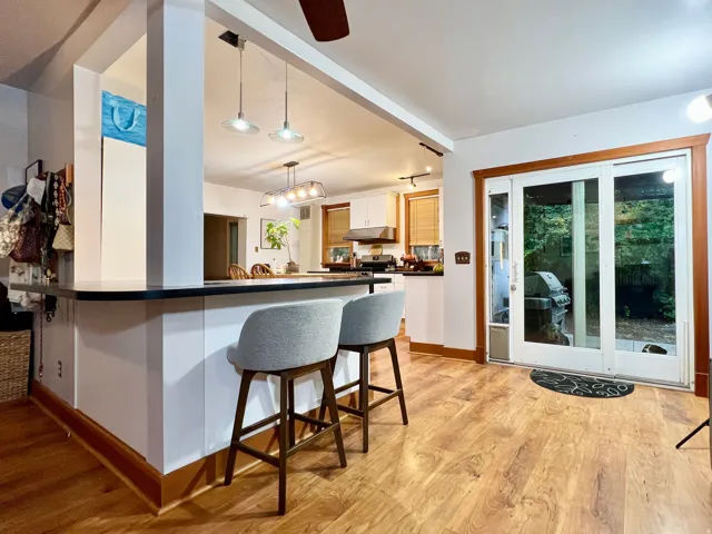 Kitchen featuring wood-finish flooring, a built-in breakfast bar, and pendant lighting