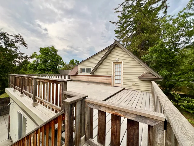 Expansive rooftop deck with wood railing, offering access to the property's exterior