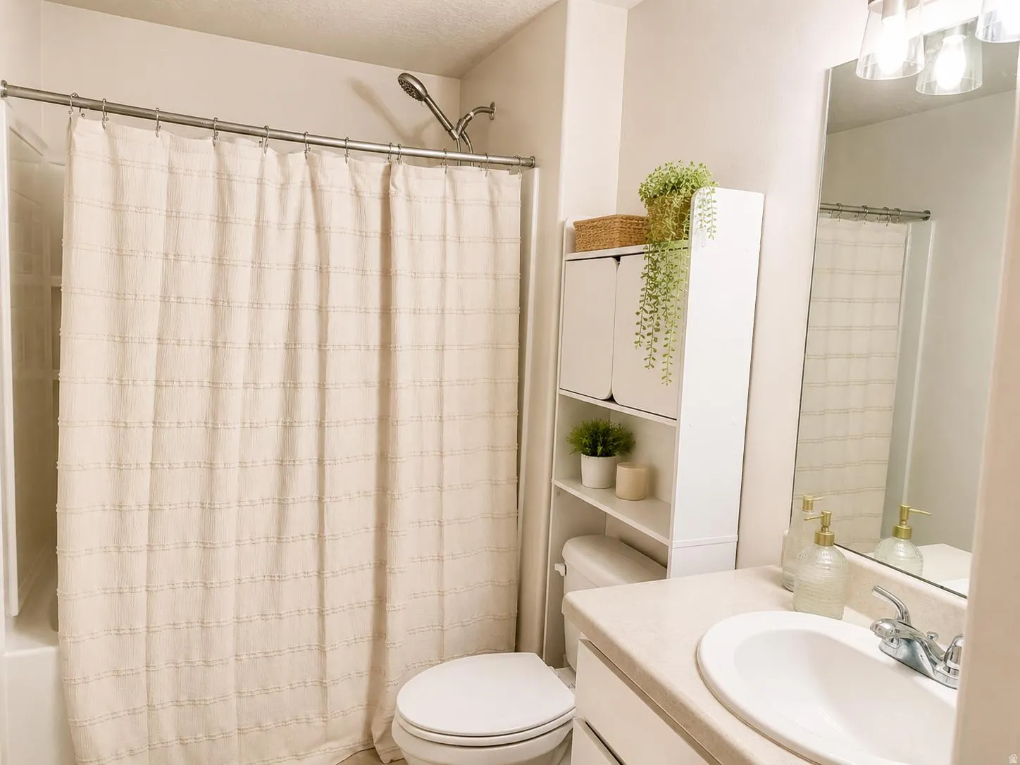 Vanity with integrated sink, chrome faucet, and overhead bar lighting