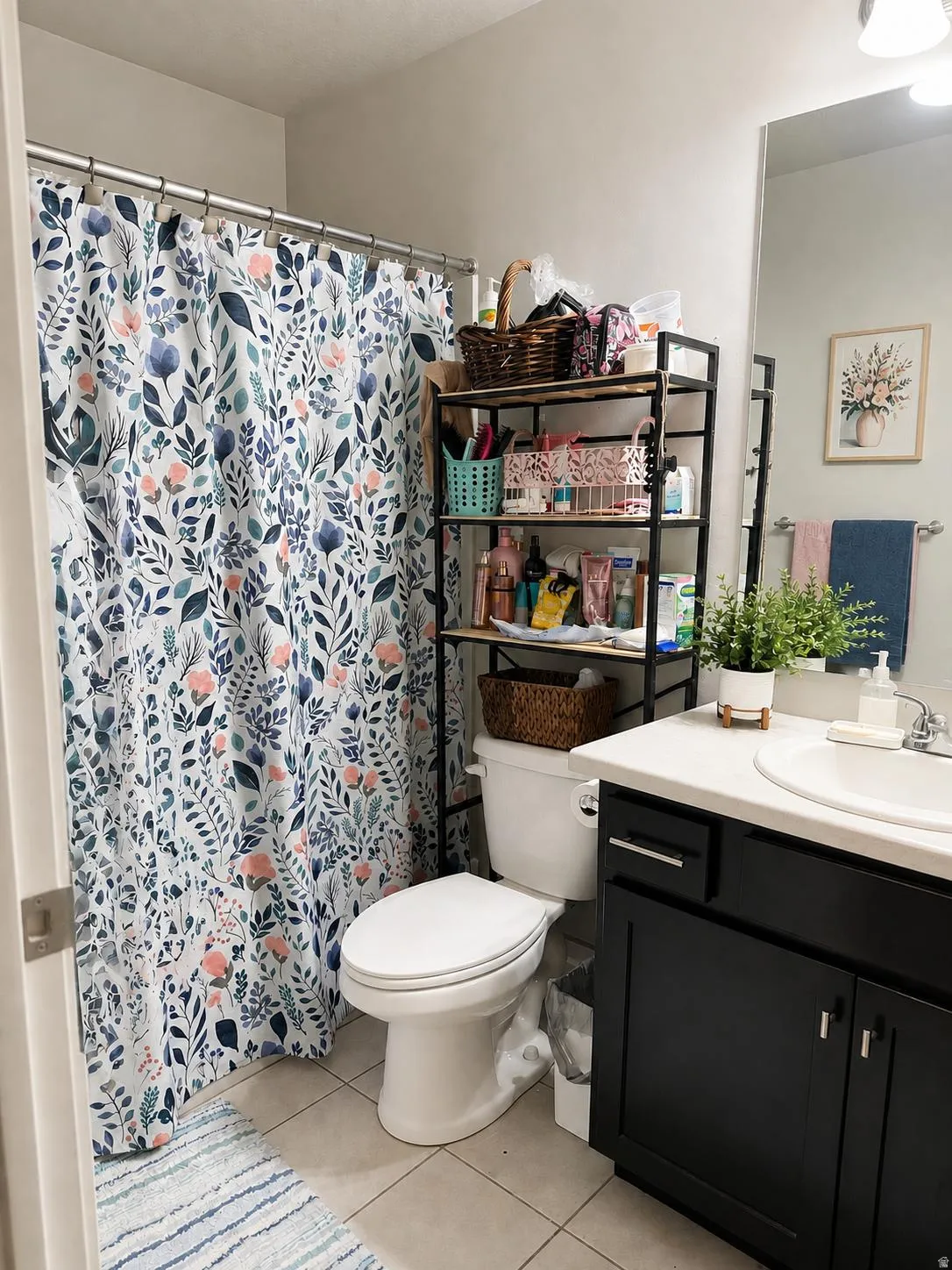 Bathroom featuring a single vanity with dark cabinetry, integrated sink, and a framed mirror