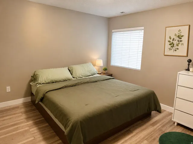 Neutral wall paint, wood-finish flooring, and a window with blinds