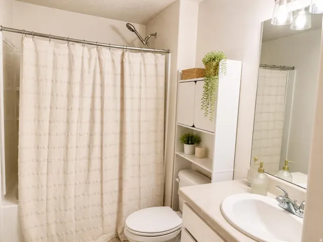 Vanity with integrated sink, chrome faucet, and overhead bar lighting