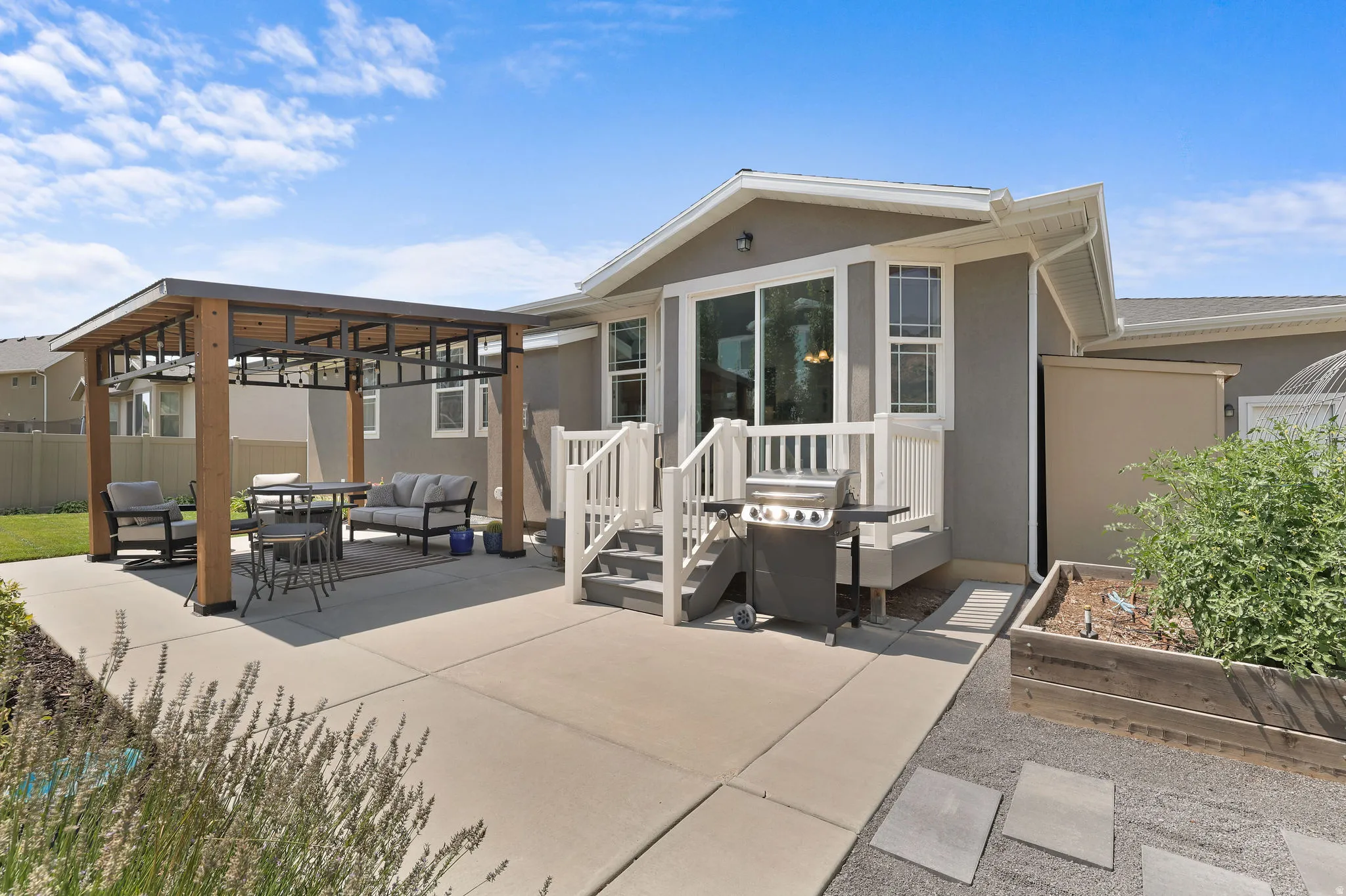 Expansive concrete patio featuring a modern pergola and a built-in wooden planter