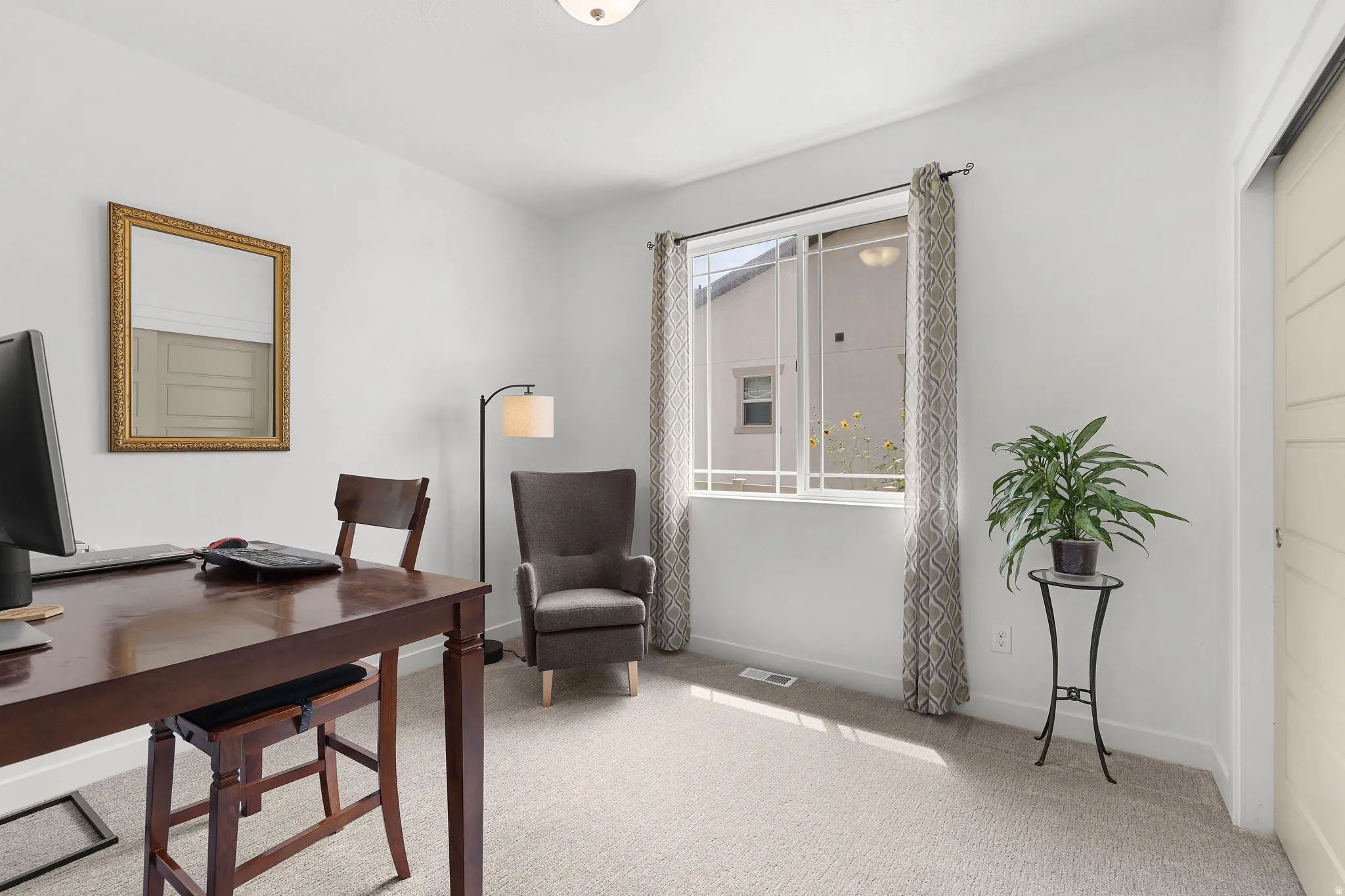 Recessed lighting illuminates the neutral-toned carpet and white walls