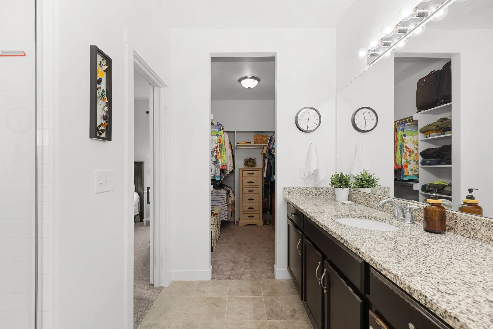 Vanity with a light-colored speckled countertop, undermount sink, and dark wood-finish cabinetry