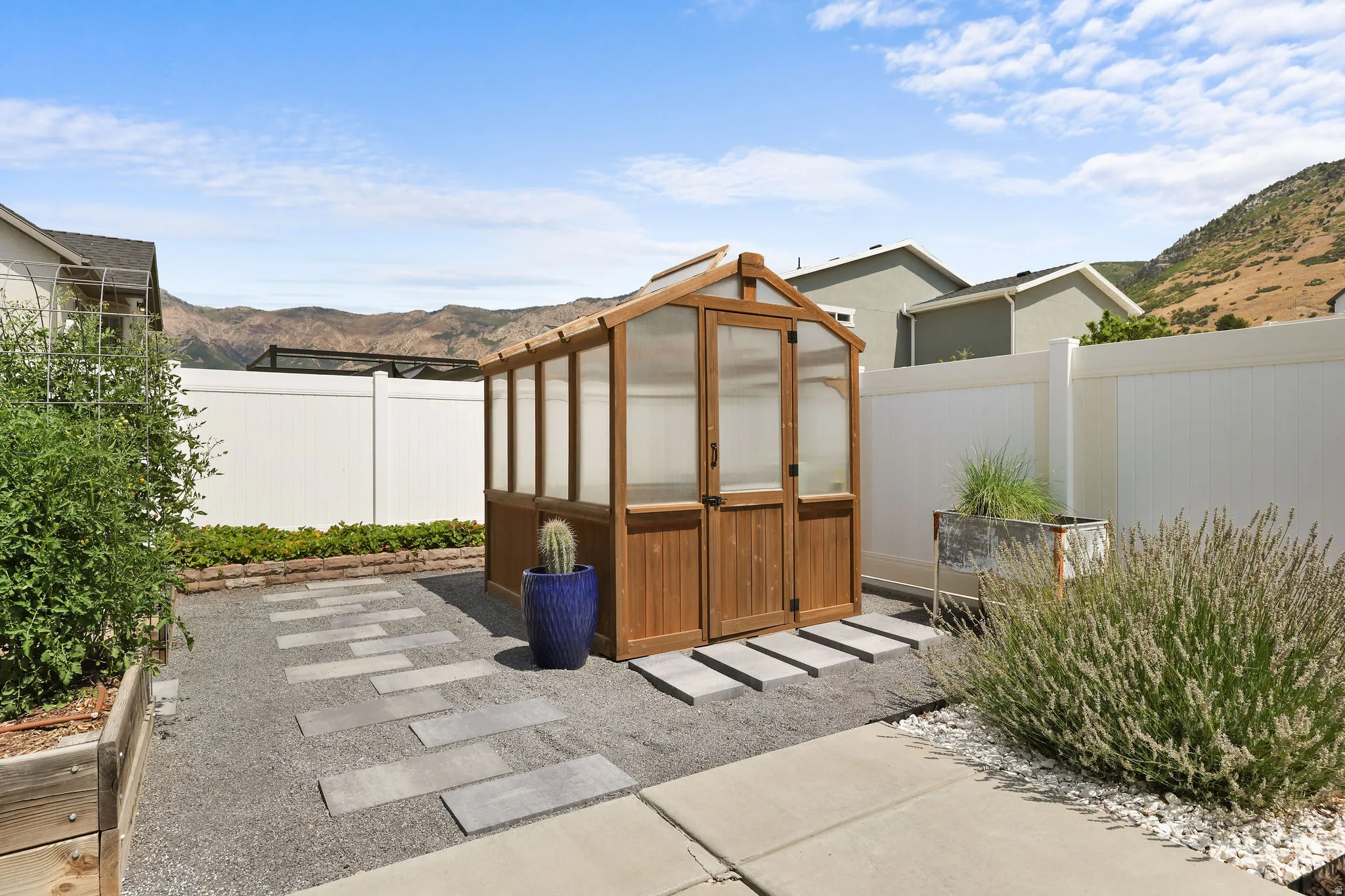 Gable-style greenhouse with transparent panels and wood-finish framing