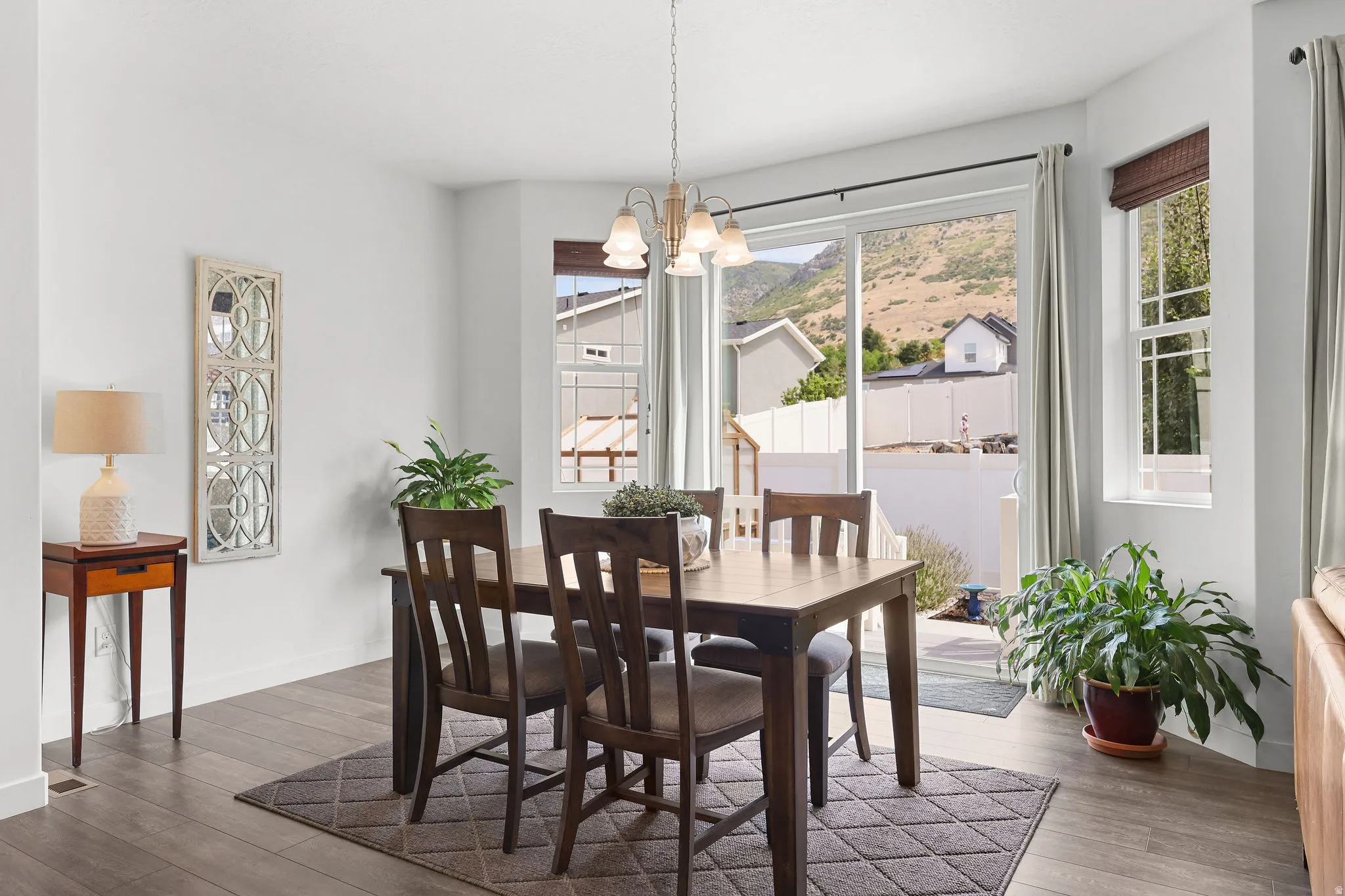 Bright dining space featuring wood-finish flooring, a sliding glass door, and a bay window