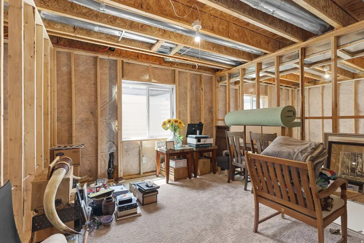 Unfinished interior space with exposed wood framing, an exposed ceiling, and a window