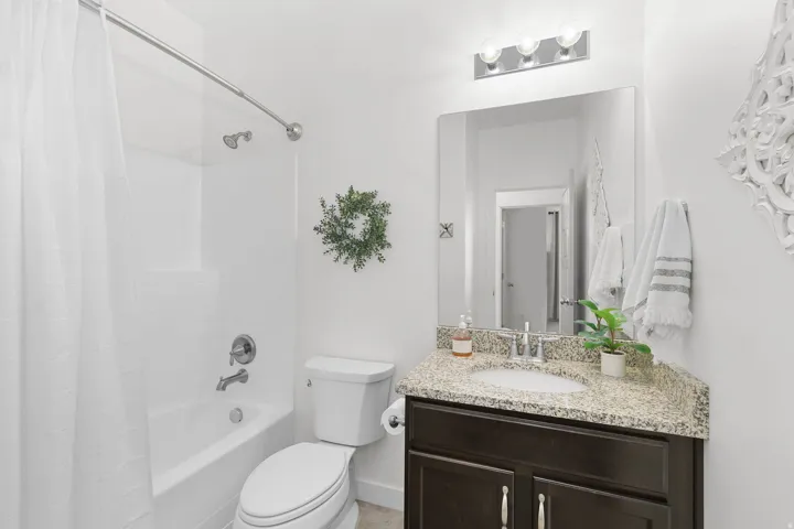 White bathtub and shower combination with a curved shower rod
