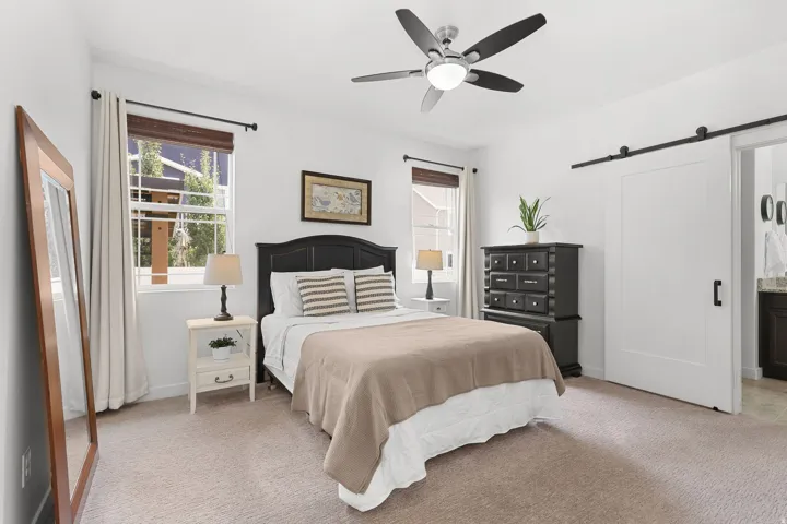 Neutral-toned carpeting paired with white walls, featuring a ceiling fan with integrated lighting