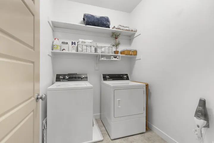 Laundry area with open shelving and tile flooring