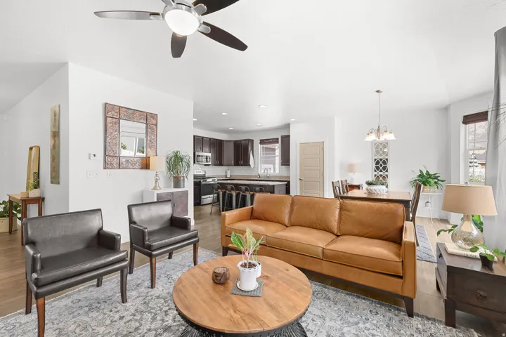 Open-concept living space featuring wood-finish flooring, a ceiling fan, and recessed lighting