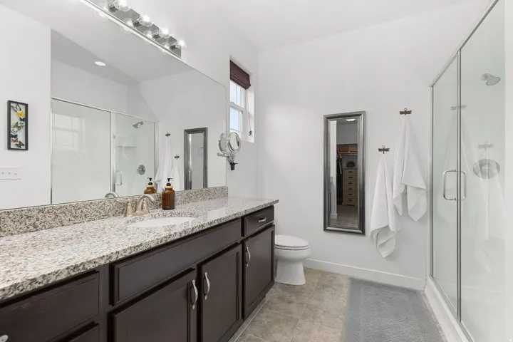 Double vanity with a granite countertop, undermount sinks, and dark wood cabinetry