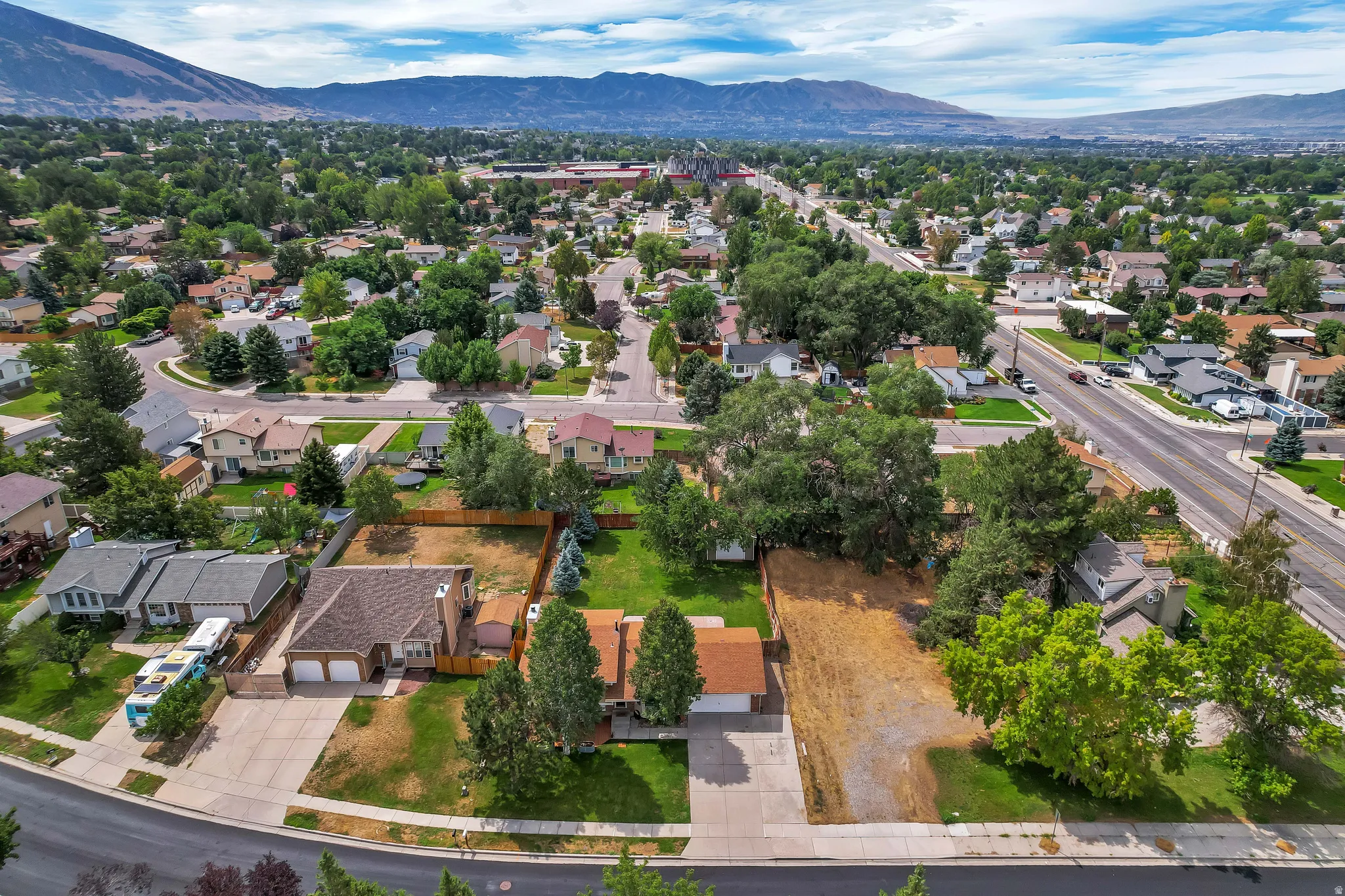 Expansive neighborhood with established trees and mountain backdrop