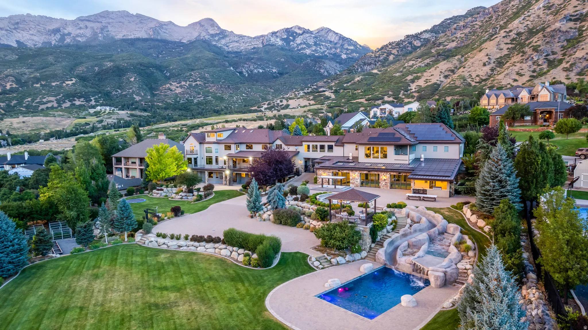 Expansive property featuring a swimming pool, custom water slide, large patio, and mature landscaping