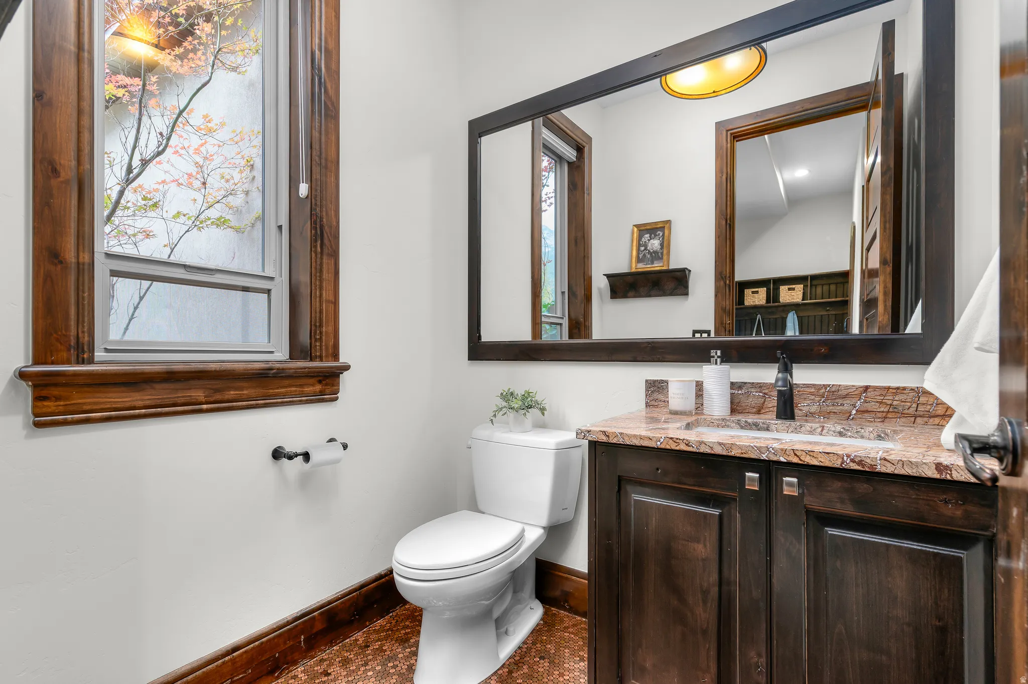 Dark wood-finish vanity with an integrated sink and stone countertop
