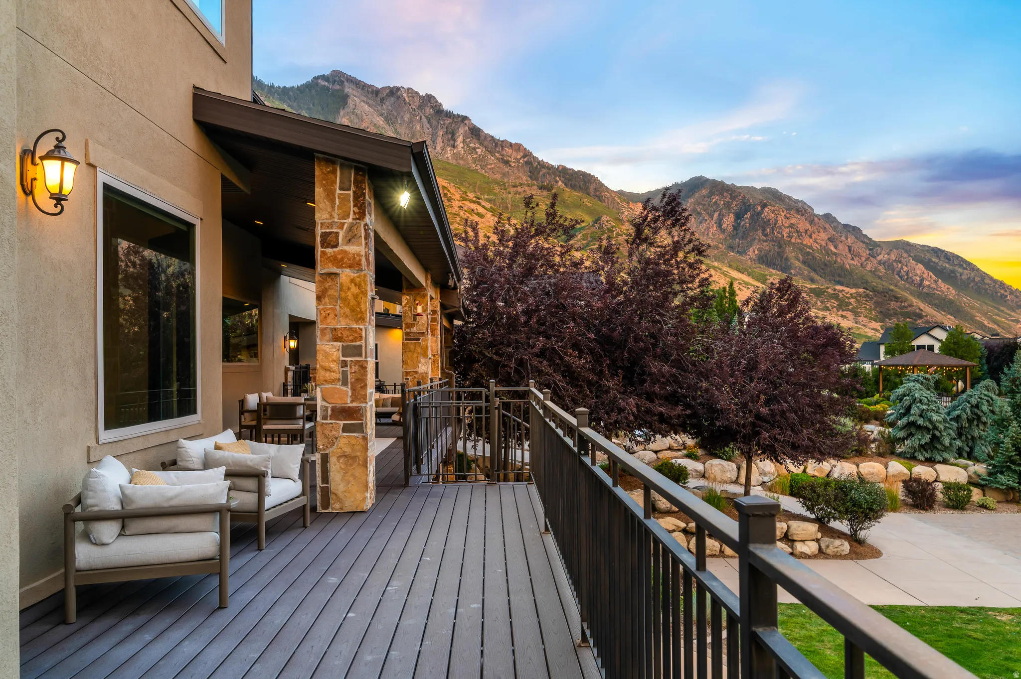 Expansive outdoor deck with composite decking, stone columns, and metal railings