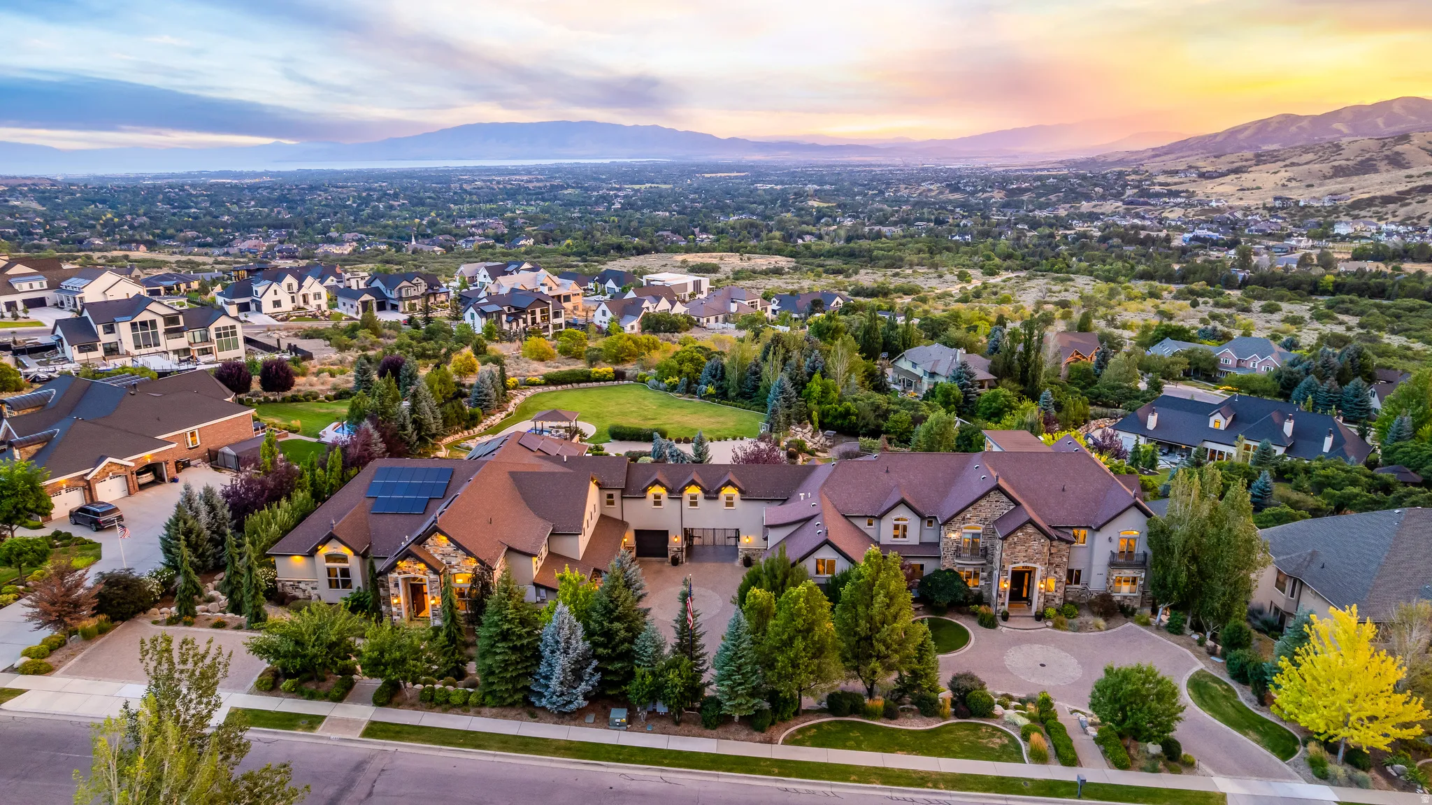Expansive property with multiple structures, mature landscaping, and an extensive circular driveway