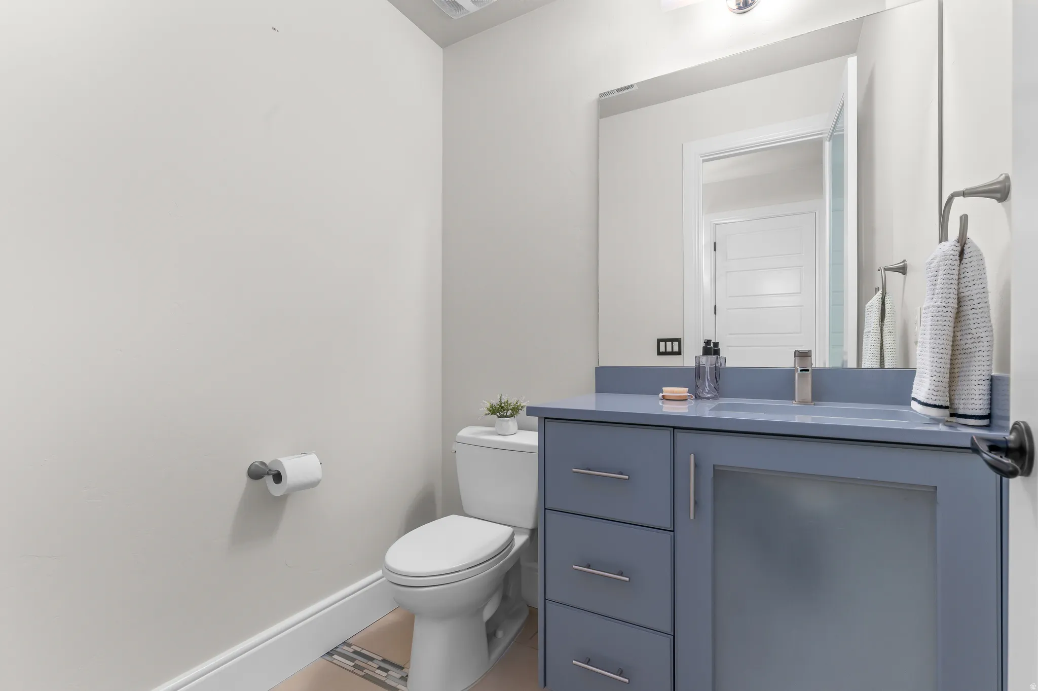 Vanity with a solid surface countertop, undermount sink, and contemporary faucet