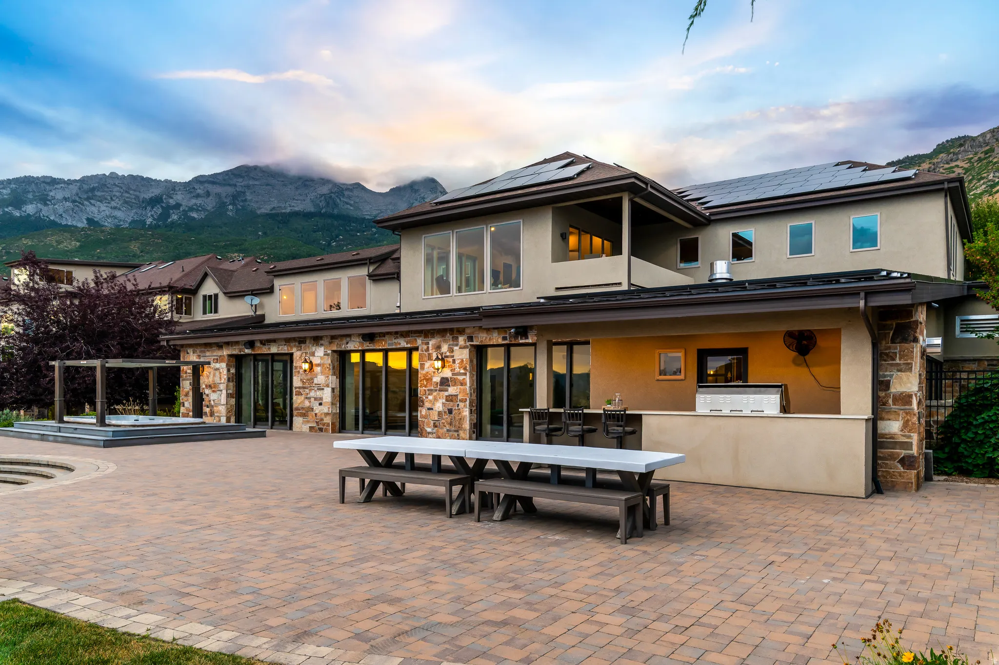 Expansive paver patio with an integrated outdoor kitchen and bar seating
