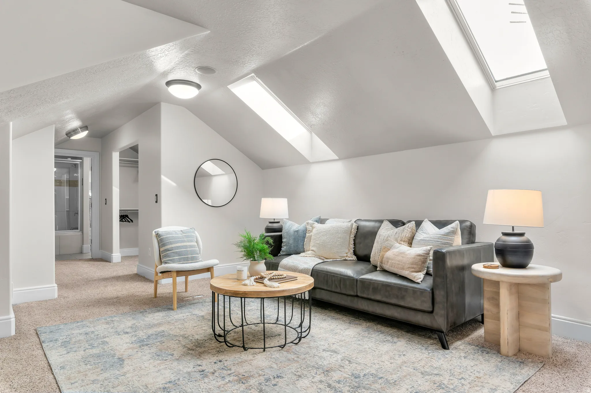 Sloped ceilings with multiple skylights, recessed lighting, and a built-in closet space