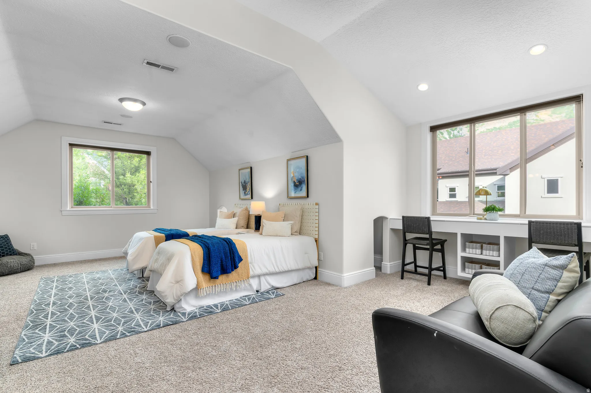 Carpeted room with sloped ceilings and recessed lighting
